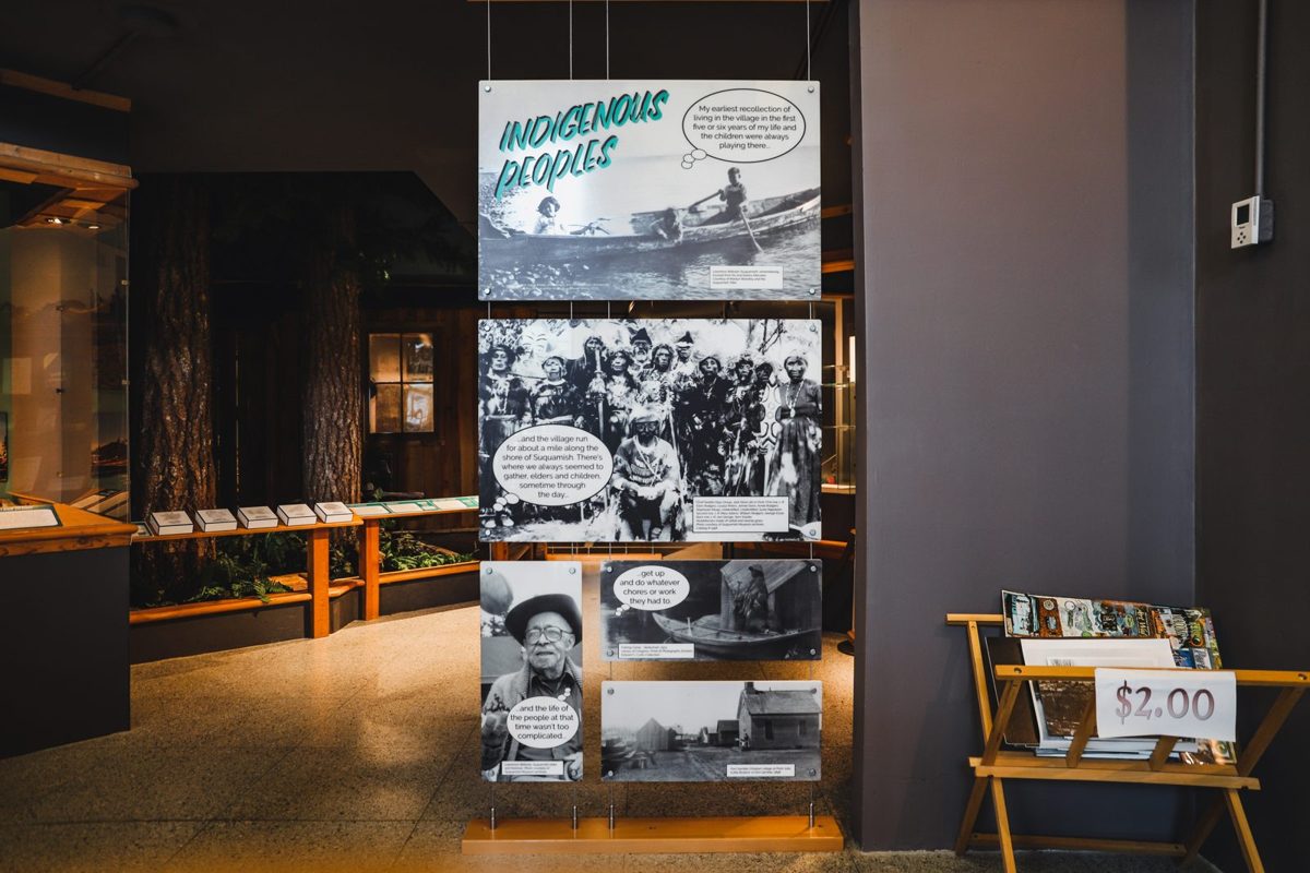 The Indigenous Peoples portal of the Kitsap Timeline gallery, with historic photographs, a cedar-tree mural and reader rails