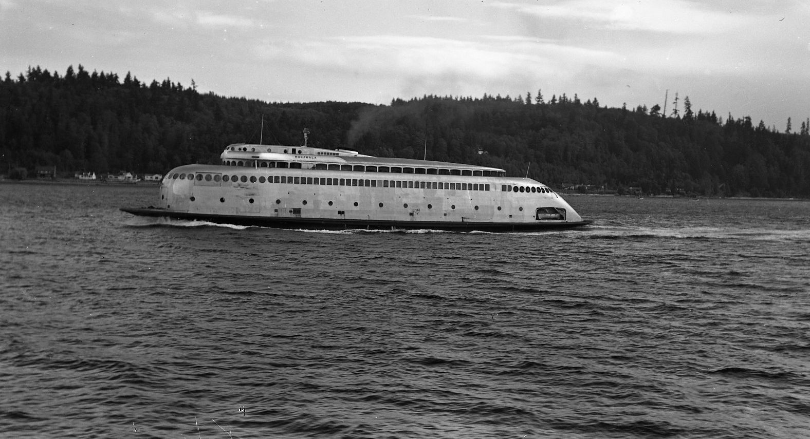 The streamlined silver ferry Kalakala under way, with a wooded shore behind