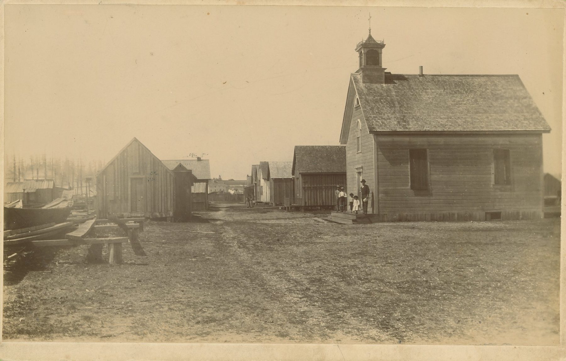 A small wooden church with a bell tower and a few nearby buildings at Little Boston
